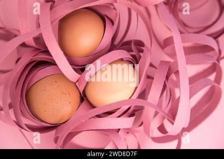 Frohe Ostern. Nahaufnahme von drei Eiern, die in farbige Bänder gewickelt sind. Fragilität und Schutzkonzept. Stockfoto