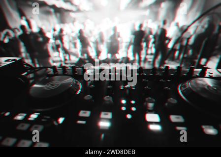 Mixer und DJ-Stand im Nachtclub bei Party c mit mehrfarbigen Tänzern auf der Tanzfläche verwischten die Leute. Schwarzweißfoto mit Glitcheffekt und Stockfoto