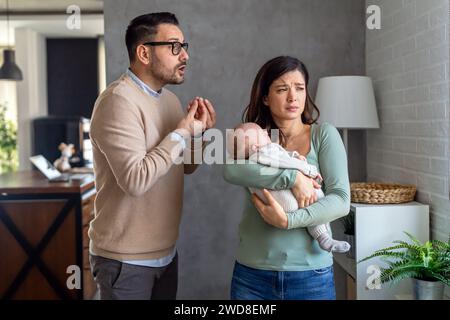 Gewalt in der Familie. Aggressiver nervöser Mann streitet mit seiner Frau, die postpartale Depression hat Stockfoto