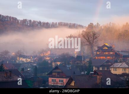 Ein ruhiges Dorf am Abend, umgeben von dichten Bäumen Stockfoto