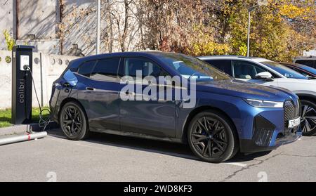 Almaty, Kasachstan - 11. November 2023: Der BMW iX xDrive40 wird an einer Elektrofahrzeugstation aufgeladen. Stockfoto