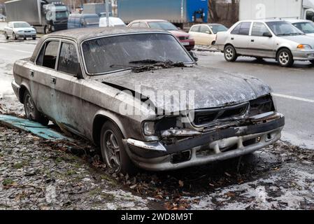 Verlassenes Auto, das von Marodeuren auf einer Stadtstraße in der Ukraine kaputt wurde Stockfoto