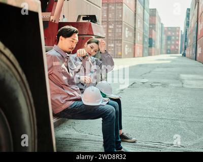 Ein Team von Ingenieuren, die sich entspannen und Wasser trinken, einen harten Tag im Container . Konzept Energie auffüllen Stockfoto