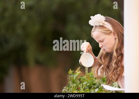 Kind, Tee und Gießen oder Ekel im Garten für groben Geschmack bei Partyveranstaltungen oder unglücklich, trinken oder enttäuscht. Weibliche Person, Mädchen und Tasse oder warm Stockfoto