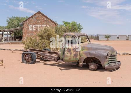 Vintage-Pick-up-Wrack, abgenutzt durch Rost in der Ausstellung an der Tankstelle in der Wüste Naukluft, gedreht im hellen Licht des späten Frühlings in Betta, Namibia, A Stockfoto