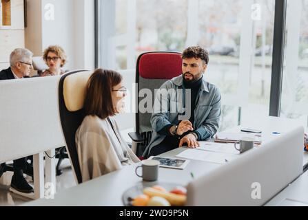 Eine Gruppe von Fachleuten verschiedener Altersgruppen, die an einem erfolgreichen Projekt in einem modernen Büro zusammenarbeiten. Stockfoto