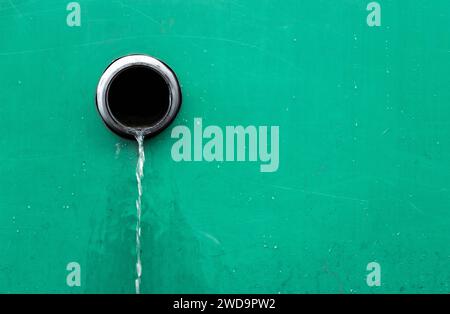 Kanalisation in der Wand mit fließendem Wasser nach Regen. System ablassen Stockfoto