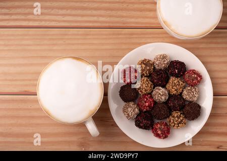 Fotografie, Süßigkeiten, Schokoladentrüffel, süß, Tasse, Cappuccino, Auswahl, Dessert, gemischt, weiß, Teller, lecker, Essen, Café, lecker, Aroma, Hintergrund Stockfoto