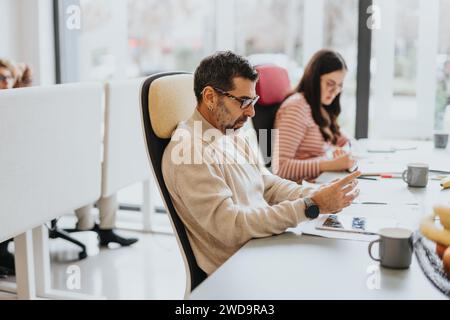 Verschiedene Altersgruppen von Mitarbeitern, die in einem modernen Büro zusammenarbeiten. Stockfoto