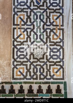 Alte islamische Fliesen (auch bekannt als zellige oder azulejos) mit traditionellen geometrischen Mustern schmücken eine Wand in der Alhambra, Andalusien, Spanien. Stockfoto