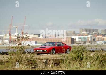 Klassischer roter Ferrari Dino 308 GT4 mit Stadtbild im Hintergrund Stockfoto