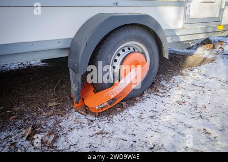 An einem Rad eines Anhängers ist eine Wegfahrsperre der öffentlichen Ordnung angebracht Stockfoto