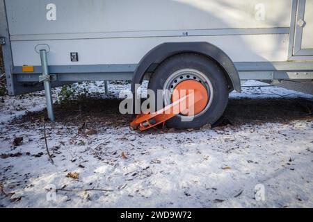An einem Rad eines Anhängers ist eine Wegfahrsperre der öffentlichen Ordnung angebracht Stockfoto