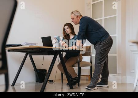 Generationenübergreifendes Team von Mitarbeitern, die in einer innovativen Büroumgebung zusammenarbeiten. Stockfoto