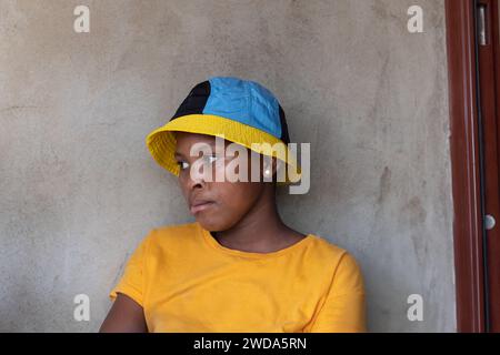 Junge afrikanerin mit Herpes simplex auf den Lippen, die draußen vor dem Haus steht Stockfoto