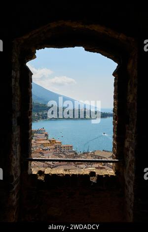 Blick durch ein Fenster über die Dächer der Altstadt von Malcesine am Gardasee in Italien Stockfoto