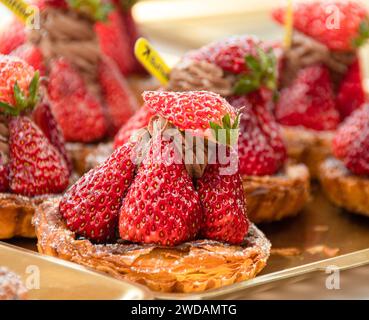 Das exquisit geformte Erdbeerbrot wird auf einem Stahlblech platziert, beleuchtet von warmen Lichtern und sieht sehr lecker aus. Stockfoto