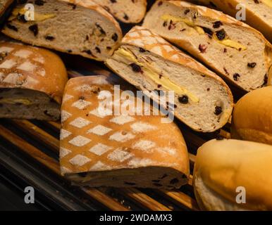 Das köstliche Brot auf Holzregalen, diese Brote haben exquisite Formen und werden von warmen Lichtern beleuchtet. Stockfoto