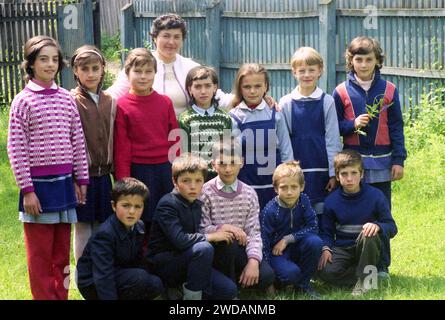 Vrancea County, Rumänien, ca. 1991. Lehrer und junge Schüler posieren für ein Foto. Stockfoto