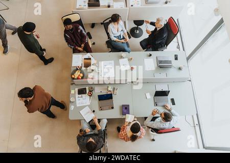 Kreative Büroumgebung mit vielfältigen Teams, die an Zusammenarbeit und Diskussion beteiligt sind. Foto von oben. Stockfoto
