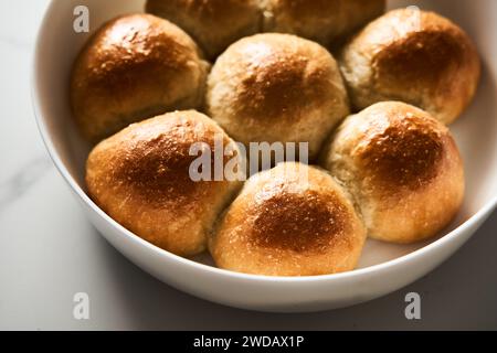 Burger-Brötchen oder Mini-Brötchen in der runden Backform. Sehr weich, frisch gebacken, hausgemacht, gebuttert. Weißer Marmorhintergrund. Minimalistisches Foto Stockfoto