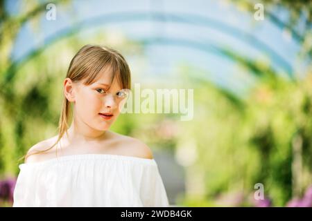 Porträt eines süßen 9-10-jährigen Mädchens in einem wunderschönen Park mit einem Bogen Stockfoto