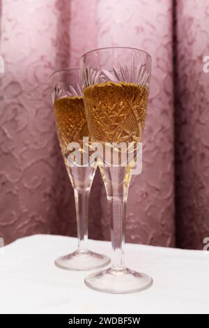 Zwei Kristallgläser mit Champagner auf einem Vorhang, Konzept im Stil der 90er Jahre Stockfoto
