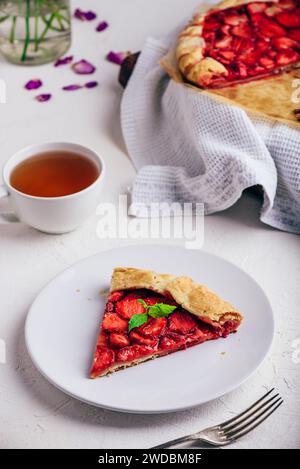 Scheibe Köstliche, Frisch Gebackene, Vegane Erdbeer-Galette Mit Minzblättern Auf Weißem Keramikplatte Stockfoto