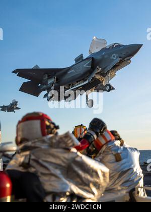 US Navy Crash und Feuerwehr Crewmen beobachten Marine Corps F-35B Lightning II, die der Marine Fighter Attack Squadron (VMFA) 225, 15. Marine Expeditionary Unit, auf dem Kampfdeck des amphibischen Angriffsschiffs USS Boxer (LHD 4) im Pazifischen Ozean landen, während sie Trägerqualifikationen durchführen, 11. Januar 2024. Die 15. MEU ist derzeit an Bord der Boxer Amphibious Ready Group, die integrierte Trainings- und Routineoperationen in der 3. US-Flotte durchführt. (Foto des U.S. Marine Corps von CPL. Amelia Kang) Stockfoto