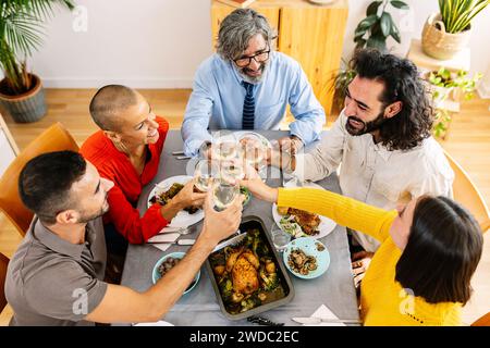 Draufsicht auf eine generationsübergreifende Gruppe von Menschen, die zu Hause zusammen zu Mittag essen Stockfoto