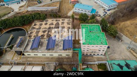 Luftaufnahme der Solarpaneele auf dem Dach des Gebäudes einer Wasseraufbereitungsanlage im ländlichen Südkorea, Südkorea Stockfoto