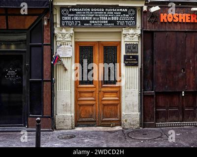 Traditionelle Holztür eines jüdischen Geschäfts mit koscheren Schildern in einer Stadtstraße, Eingang zur Synagoge. Paris Stockfoto