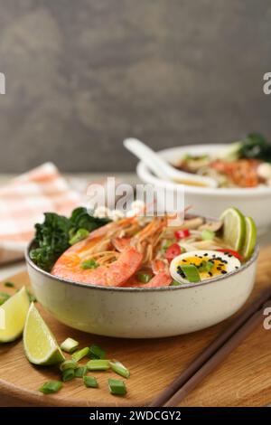 Köstliche Ramen mit Garnelen und Ei in Schüssel serviert auf dem Tisch, Nahaufnahme. Nudelsuppe Stockfoto