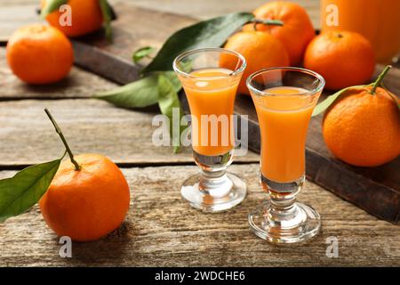 Köstlicher Mandarinenlikör und frisches Obst auf Holztisch Stockfoto