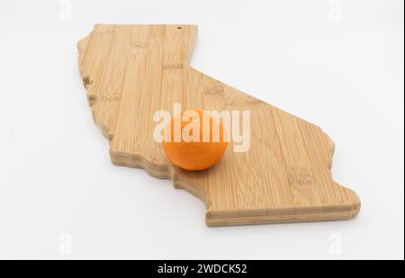 Kleines Orange am Standort von Orange County auf einem Schneidebrett in der Form Kaliforniens Stockfoto