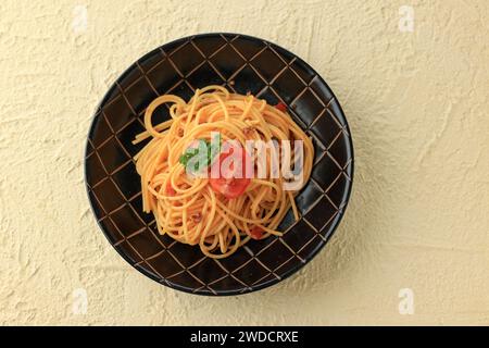 Pasta Spaghetti Bolognese in schwarzer Platte auf cremestrukturiertem Hintergrund. Bolognaise Sauce ist ein Gericht der klassischen italienischen Küche. Beliebte Italienische Küche. Stockfoto