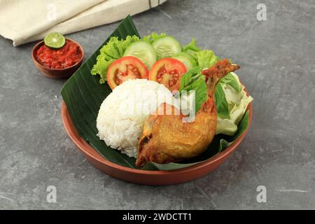 Ayam Goreng mit Nasi und Sambal, gebratenes Hühnchen nach indonesischer Art, serviert mit gedämpftem Reis und scharfer Paste Stockfoto