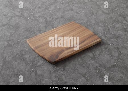 Schneidebrett auf einem Holztisch. Kulinarischer Hintergrund. Leeres Schneidebrett aus Holz, Ausstellungsfläche für Produkte. Stockfoto