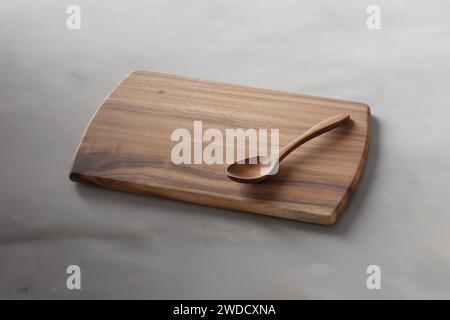 Schneidebrett auf einem Holztisch. Kulinarischer Hintergrund. Leeres Schneidebrett aus Holz, Ausstellungsfläche für Produkte. Stockfoto