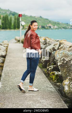 Außenporträt einer schönen brünetten Frau mit brauner Lederjacke Stockfoto