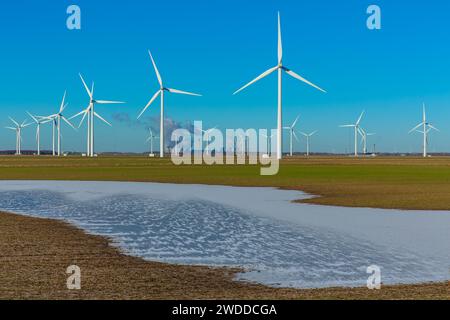 Windturbinenfarm in der Nähe von Goole in East Yorkshire mit gefrorenem Hochwasser und Drax Power Plant im Hintergrund mit aufsteigenden Wolken von Wasserdampf. Sp Stockfoto