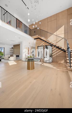 Geräumiges Zimmer mit Holzmöbeln und hoher Decke, Neubauhaus in Tarzana, Kalifornien Stockfoto