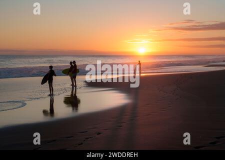 Eine Gruppe von Surfern betrachtet die Schönheit des Ozeans, mit Nostalgie und Melancholie. Gelegen am Strand Etang-Salé, auf der Insel Reunion. Stockfoto