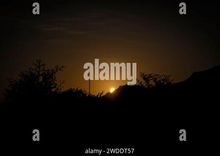 Wunderschöne goldene Stunde Sonnenaufgang hinter den Bergen im Winter in Hatta. Stockfoto