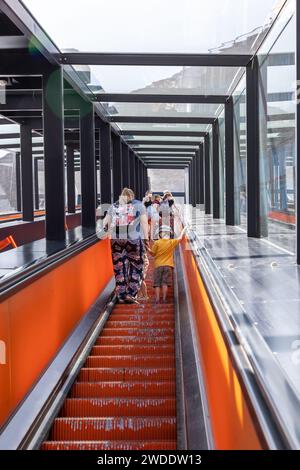 Duisburg, Deutschland - 16. Juli 2021: Eine Frau mit Kind und eine Gruppe junger Mädchen, die auf einer Rolltreppe hochfahren Stockfoto