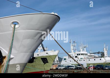 VIGO, SPANIEN - Decembro/19/2021: Zwei Bögen von Fischerbooten, mit den Seilen, die sie mit dem Hafen oder einem anderen Boot verbinden, im Hintergrund Stockfoto