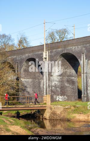 Spaziergänge durch die Landschaft von Cheshire, über eine Brücke über den Fluss Dean am Fuße des Eisenbahnviadukts in Wilmslow Cheshire Stockfoto