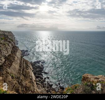 Felsige Küste, Meer und Sonnenlicht scheinen durch Wolkenlücken. Wunderschöner Naturhintergrund. Stockfoto