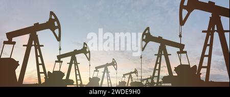 Silhouette der Ausrüstung der Ölindustrie auf dem Hintergrund der Sonnenuntergang-Wolken. Ölpumpenheber. Stockfoto
