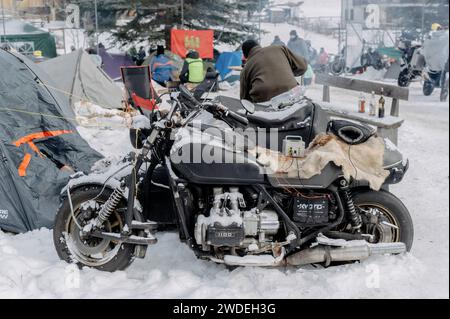 Pontechianale (Cuneo), Italien. Januar 2024. Das Agnellotreffen ist eine der höchstgelegenen Motorradrallyes in Europa. Sie findet jedes Jahr in den Wintermonaten in Pontechianale in der Provinz Cuneo (Piemont) statt und hat in diesem Jahr ihre zehnte Auflage erreicht. Die Veranstaltung zieht Motorradfahrer aus ganz Europa an, die drei Tage gemeinsam in Zeltlagern unter freiem Himmel verbringen. Auf diesem Bild sehen Sie eines der Tausenden von Motorrädern, die bei der Rallye anwesend sind, im Schnee geparkt, der in der Nacht fiel. Quelle: Luca Prestia / Alamy Live News Stockfoto